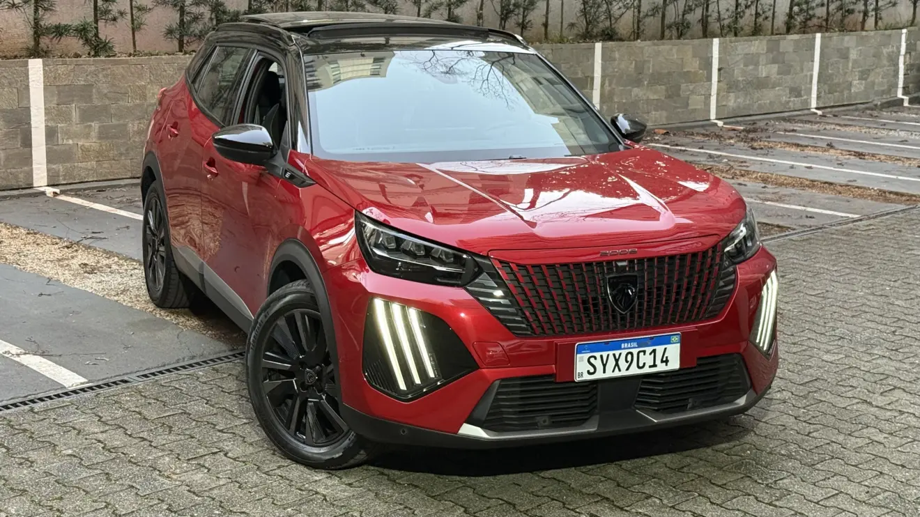 Peugeot e-2008 GT vermelho com partes pretas, DRL's acesos e visto de frente