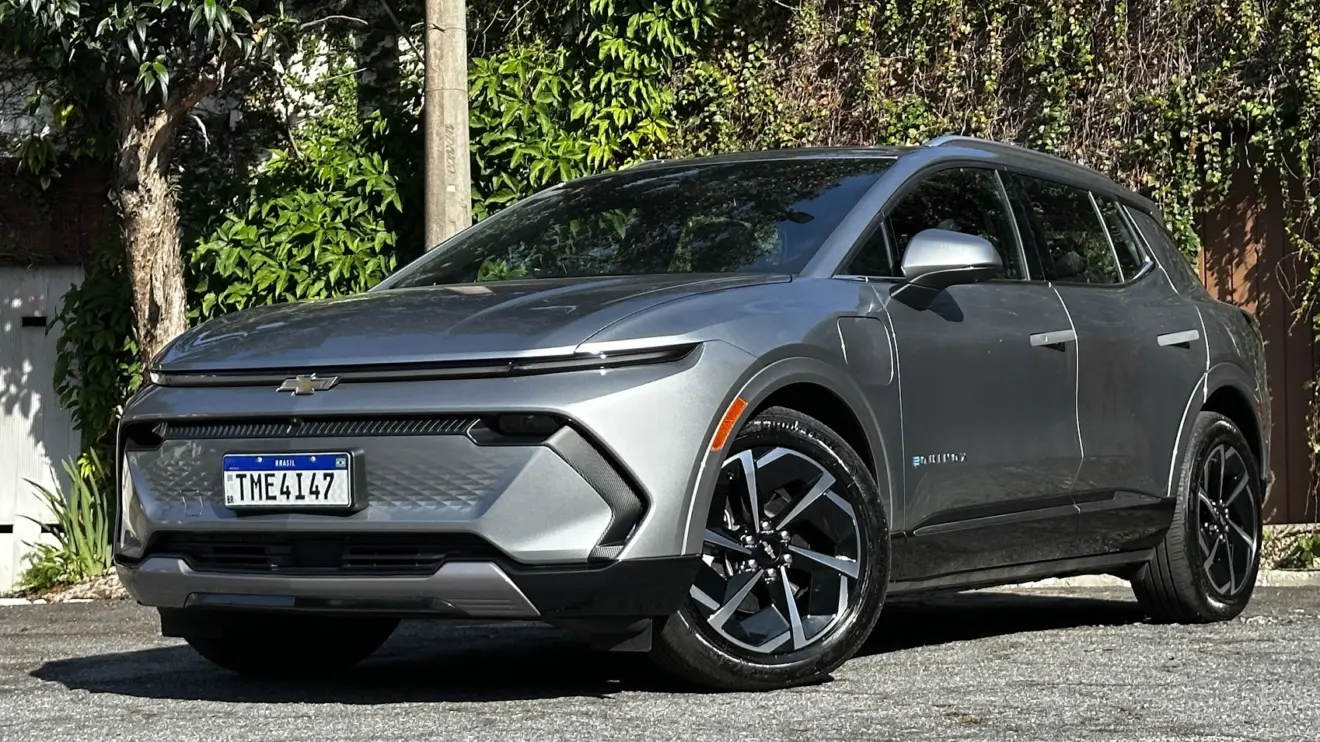 Chevrolet Equinox EV AWD prata parado de frente com muro e plantas ao fundo