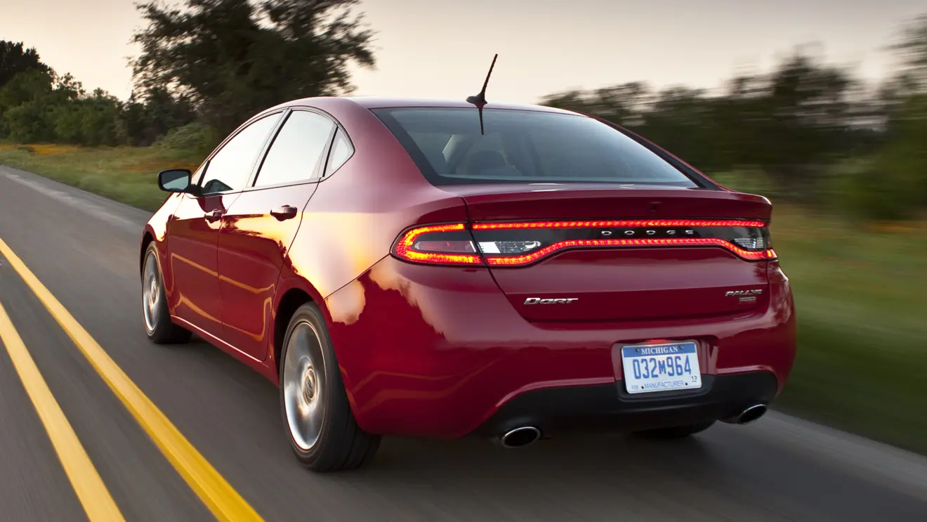 Dodge Dart vermelho de traseira andando na estrada 