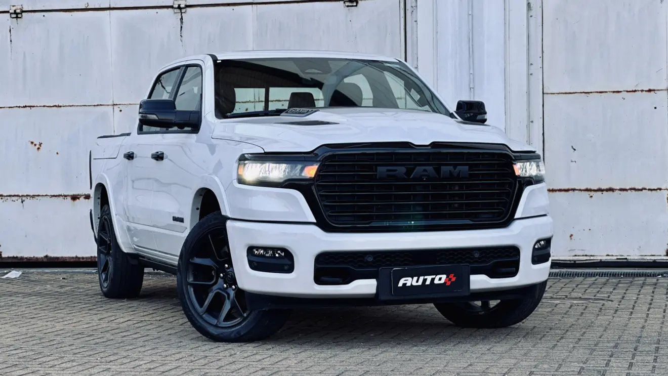 Ram 1500 Laramie Night Edition branca com detalhes pretos de frente com uma parede branca ao fundo