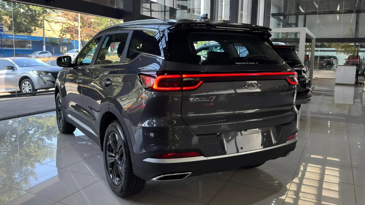 Caoa Chery Tiggo 7x Sport na cor cinza estático de traseira com lanternas ligadas