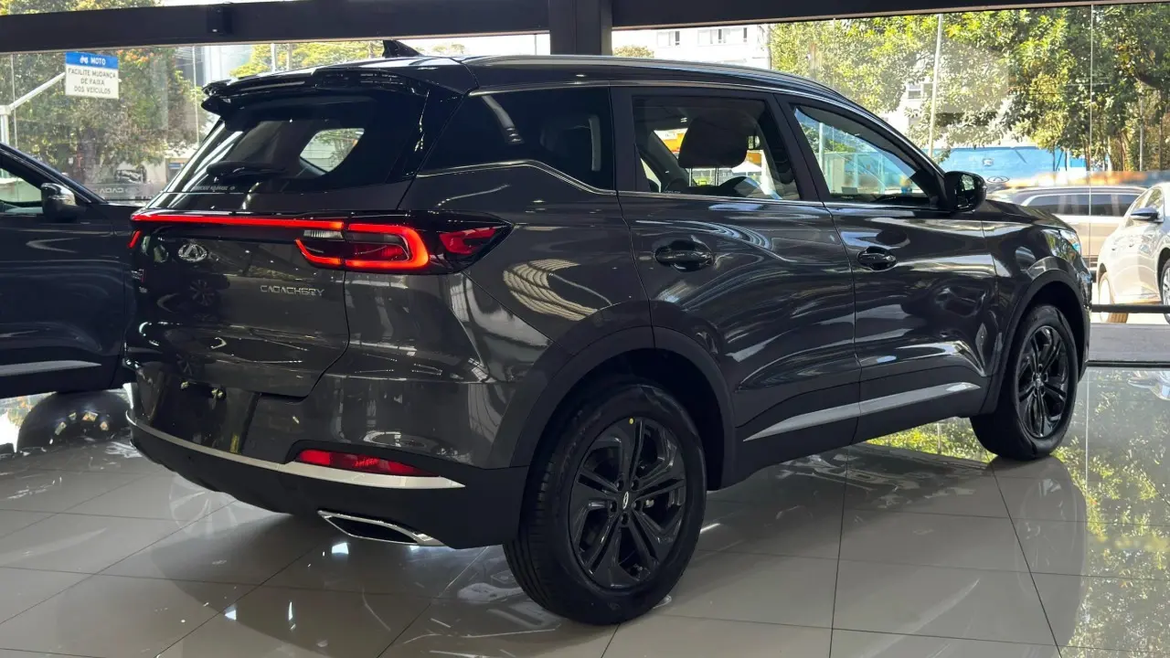 Caoa Chery Tiggo 7x Sport na cor cinza estático de traseira com lanternas ligadas