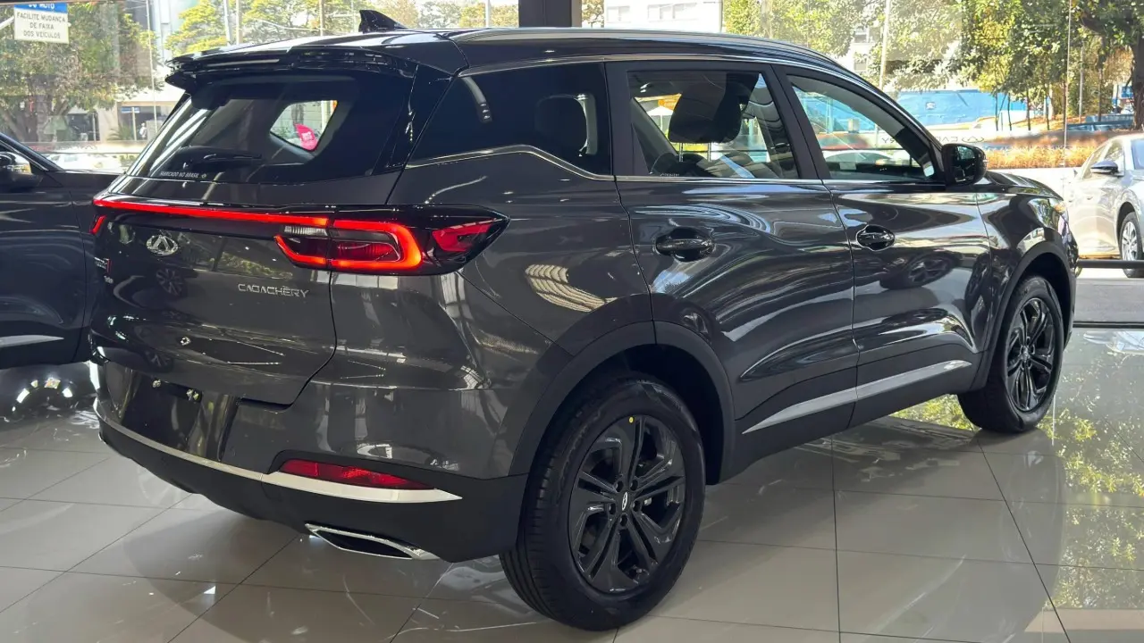 Caoa Chery Tiggo 7x Sport na cor cinza estático de traseira com lanternas ligadas