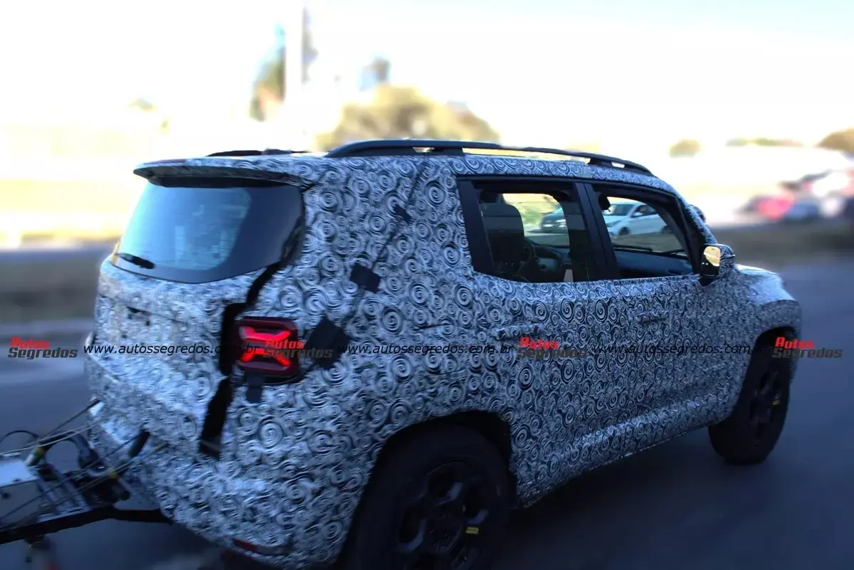 Protótipo do Jeep Renegade camuflado, visto de lado e com lanternas acesas