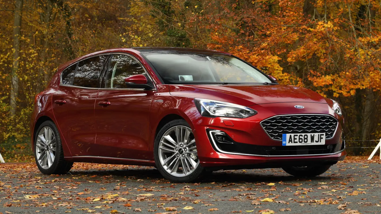 Ford Focus Vignale vermelho parado de frente com árvores ao fundo