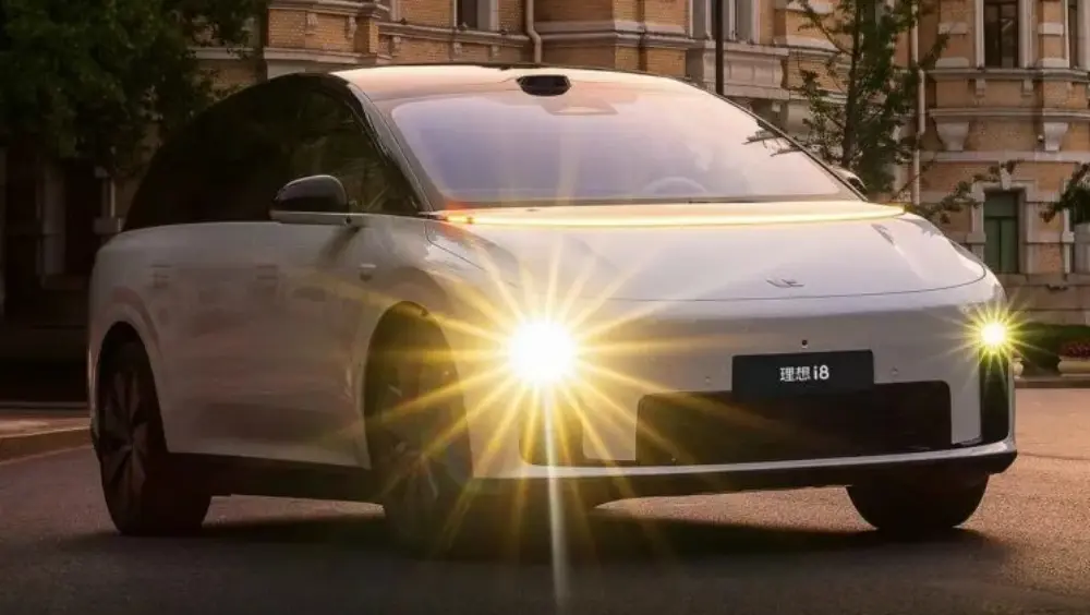 Li Auto i8 branca vista de frente e com faróis acesos
