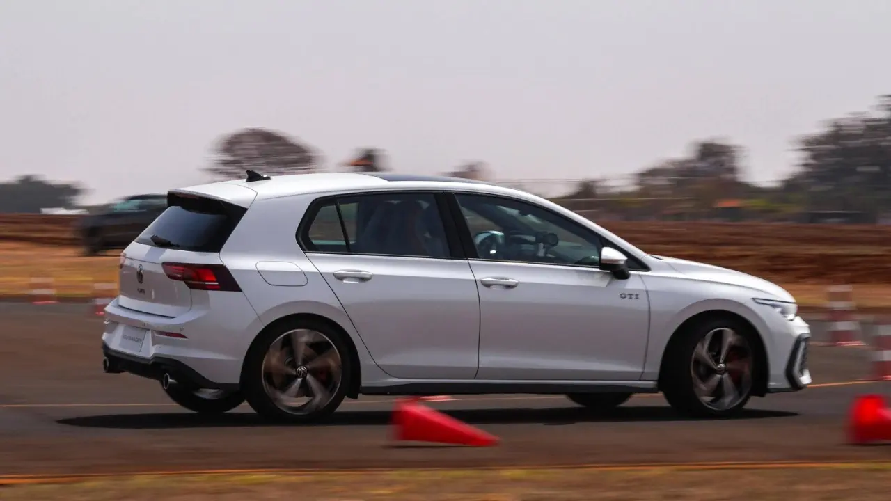 Volkswagen Golf GTI na pista em movimento cor branco fazendo curva