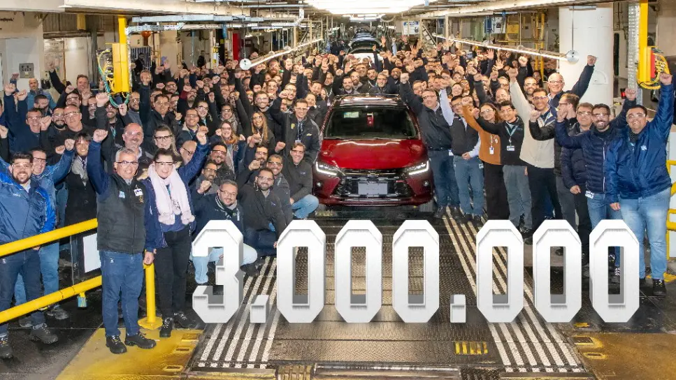 Chevrolet Onix RS vermelho visto de frente ao lado de funcionários