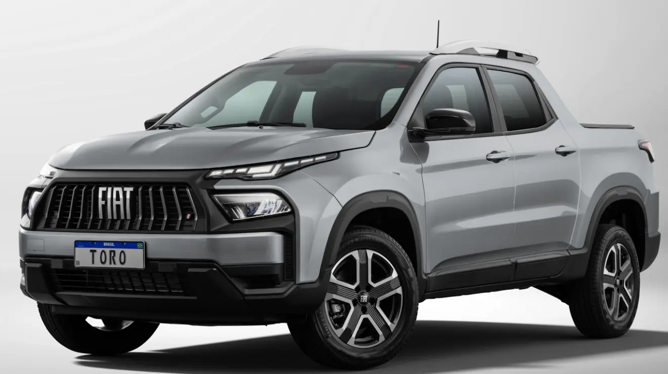 Fiat Toro Freedom 2026 cinza, vista de frente e com faróis e DRL's acesos