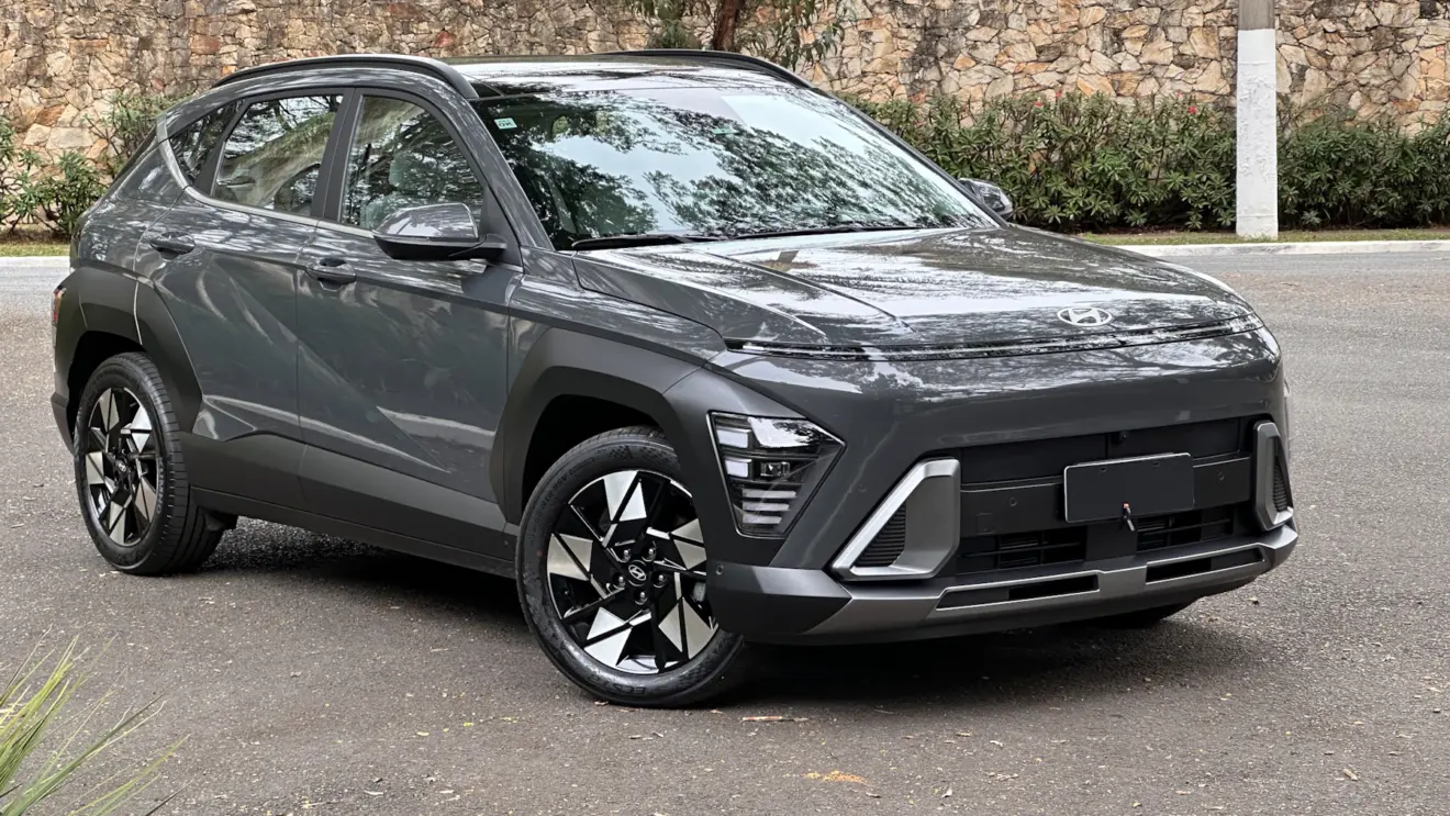 Hyundai Kona cinza parado de frente com muro ao fundo
