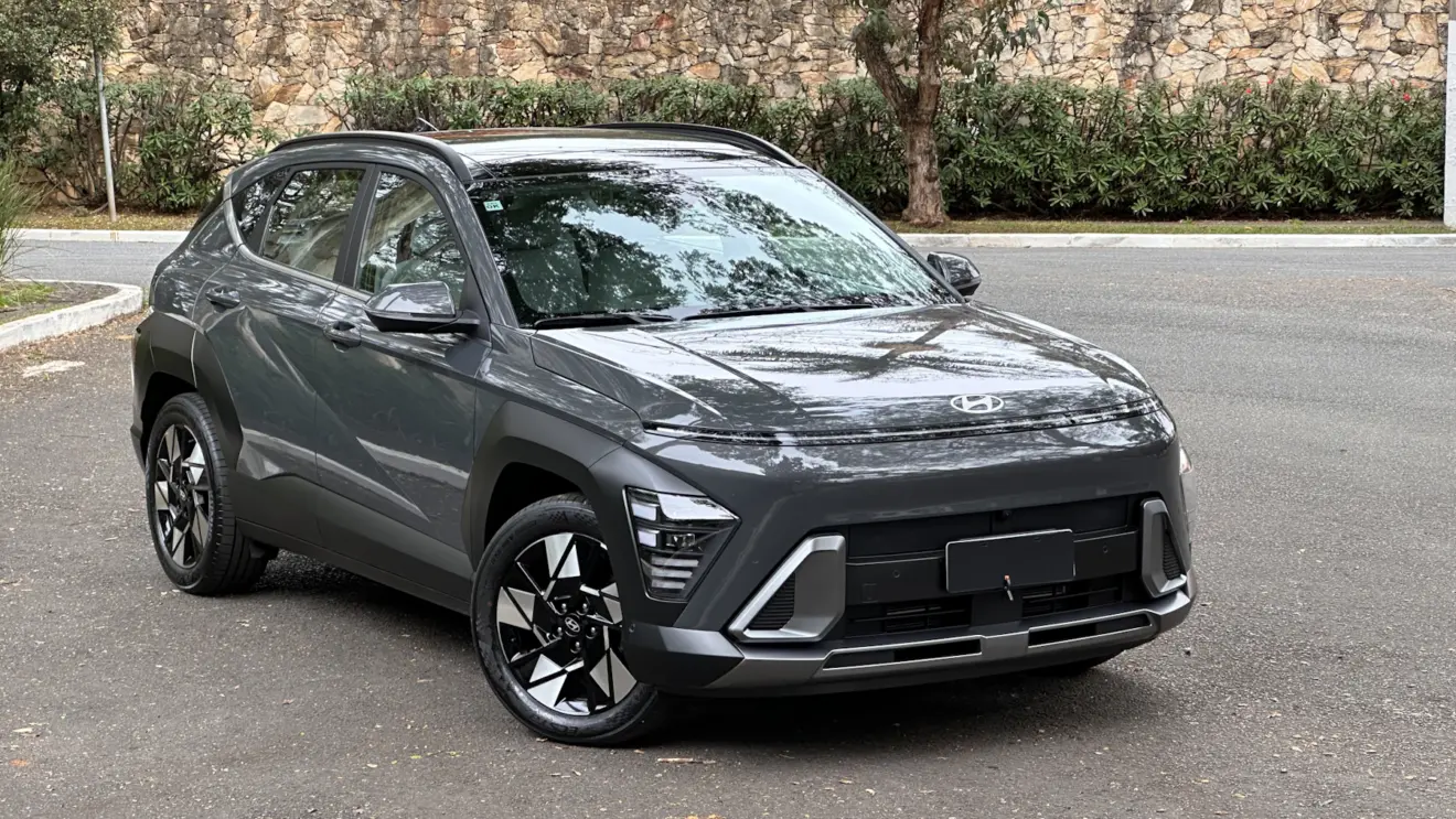 Hyundai Kona cinza parado de dianteira com muro ao fundo