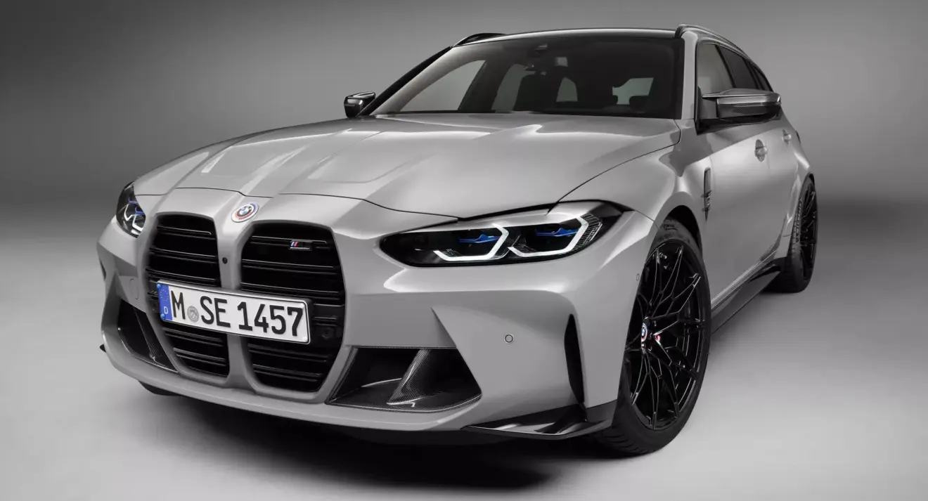 Perua BMW M3 Touring prata parada de frente com fundo neutro