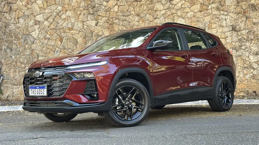 Chevrolet Tracker RS 2026 vermelho parado de frente com muro de pedras ao fundo
