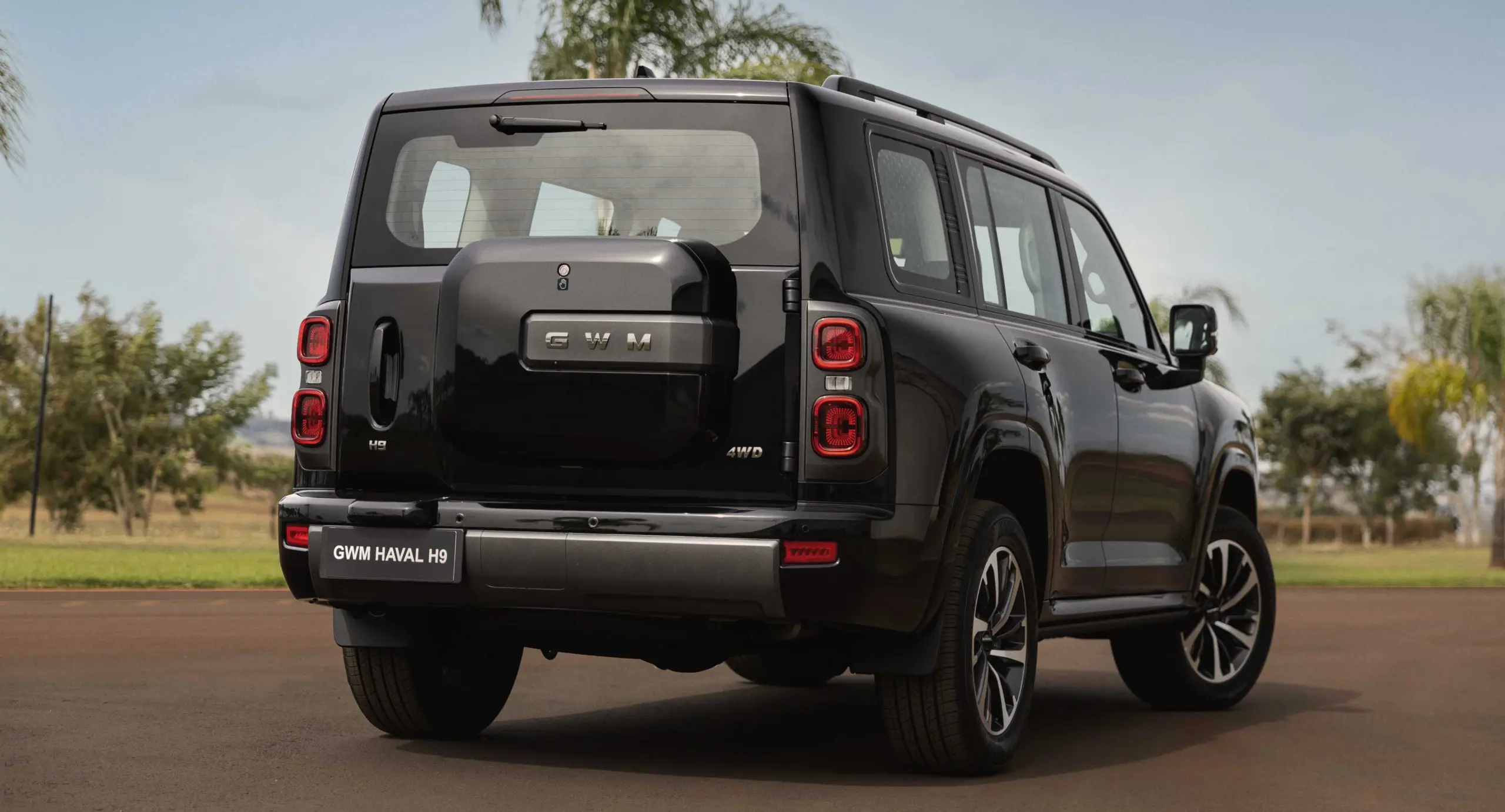 GWM Haval H9 preto parado de traseira com árvore ao fundo