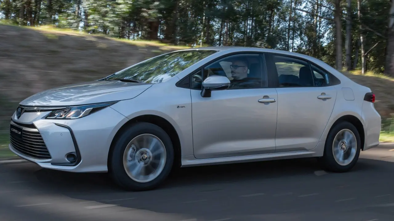 Toyota Corolla GLi Hybrid prata em movimento de lado