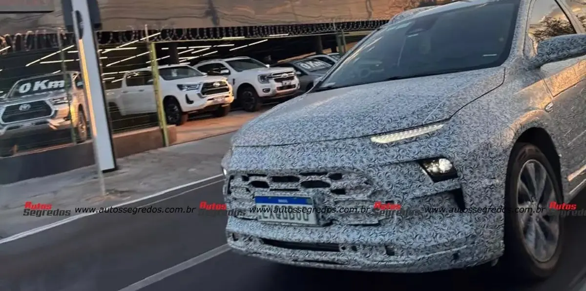 SUV derivado do Chevrolet Onix de frente andando camuflado na cidade
