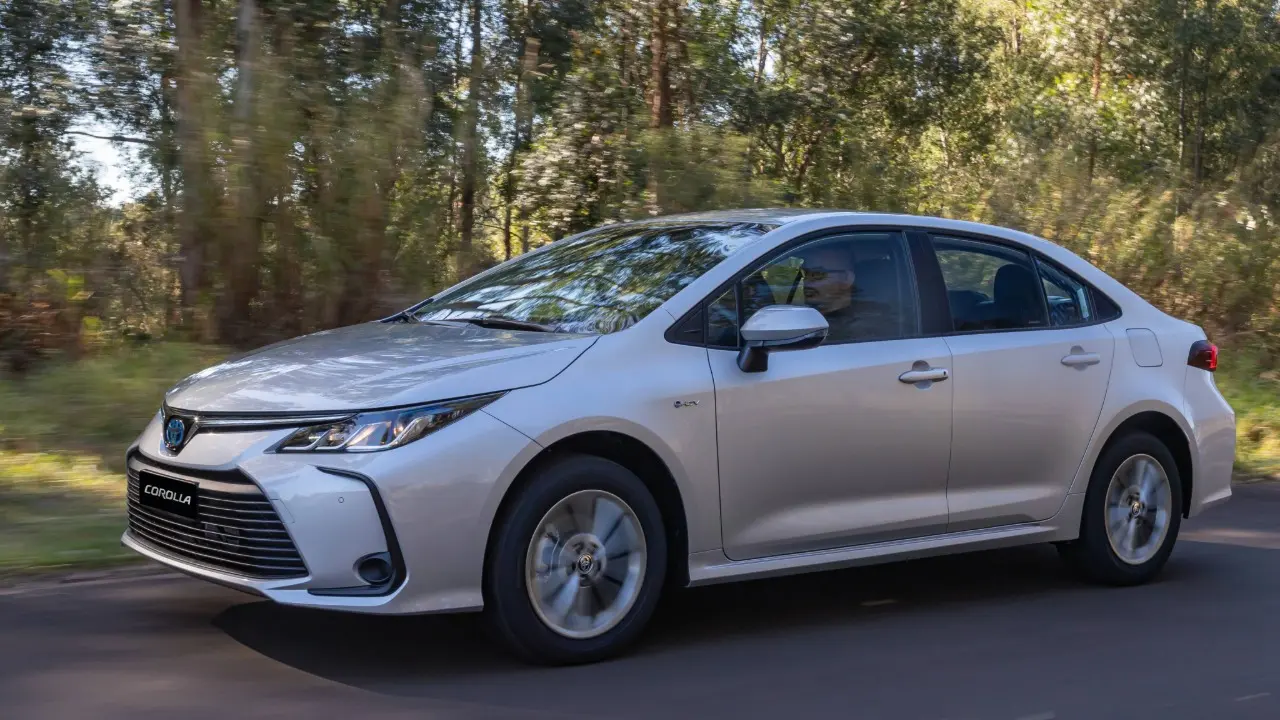 Toyota Corolla GLi Hybrid prata em movimento de lado