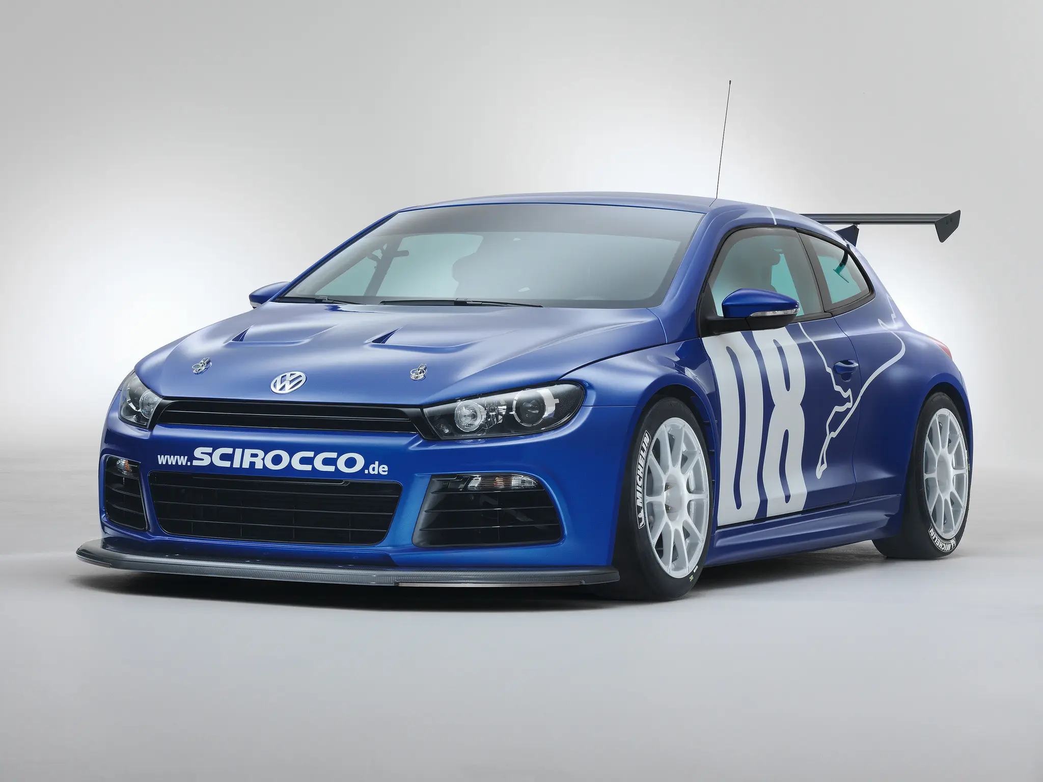 Volkswagen Scirocco GT24 azul parado de frente com fundo neutro