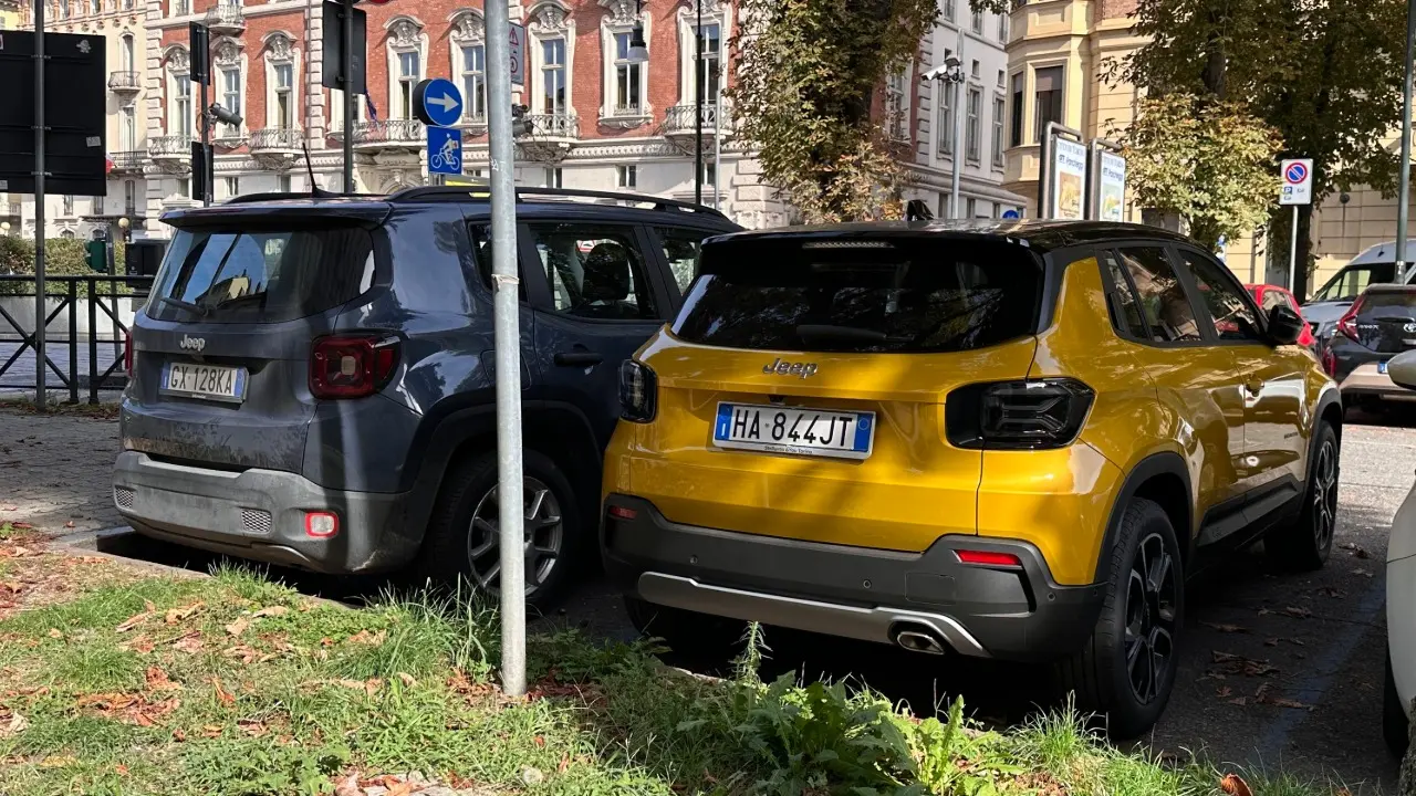 Jeep Avenger amarelo e Jeep Renegade azul estacionados lado a lado na Itália