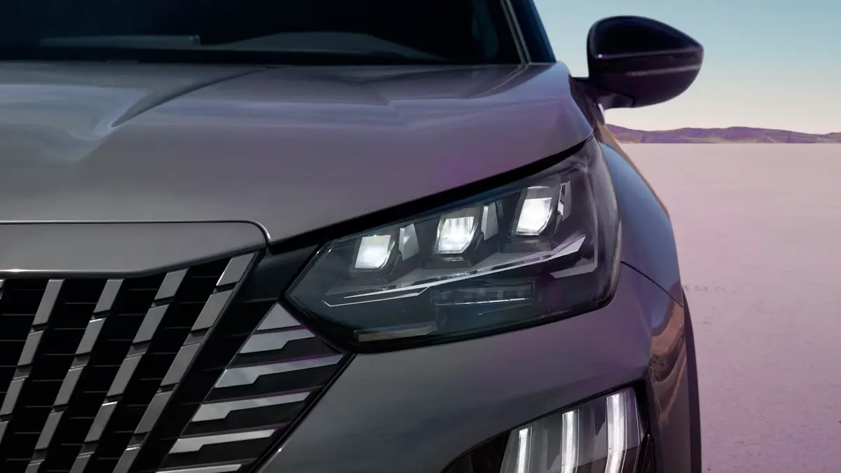 Peugeot 2008 cinza de frente mostrando o farol e o retrovisor