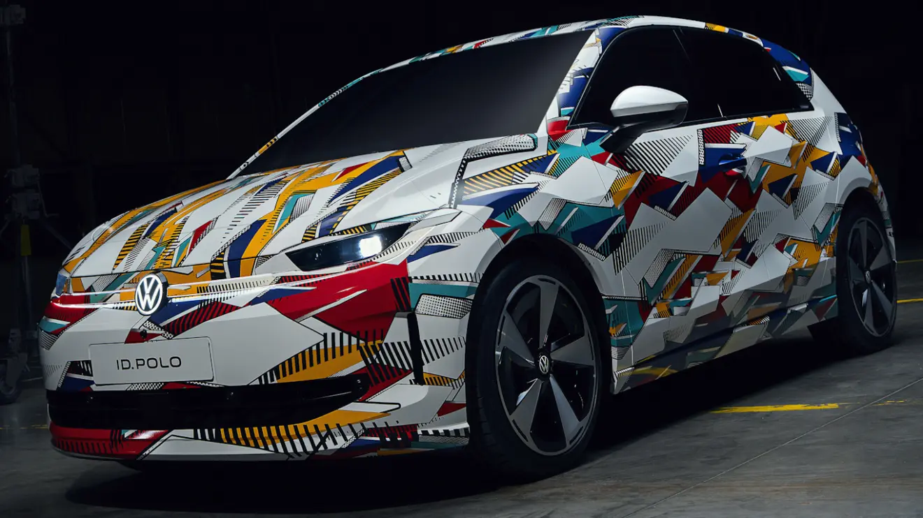 Volkswagen ID. Polo camuflado de colorido, visto de frente e com faróis acesos