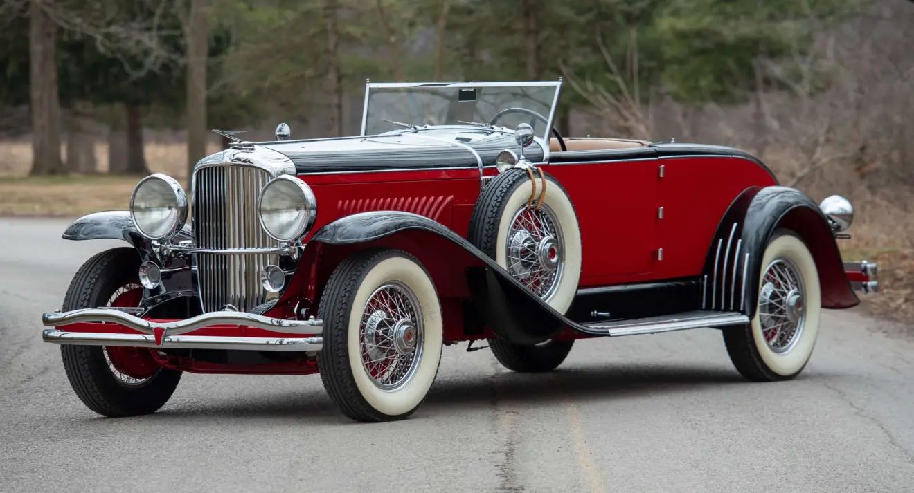 Duesenberg Model J vermelho e preto parado de frente
