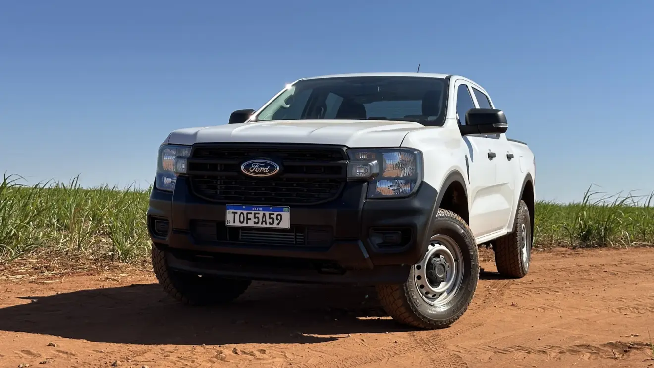Caminhonete Ford Ranger XL branca parada de frente em estrada de terra