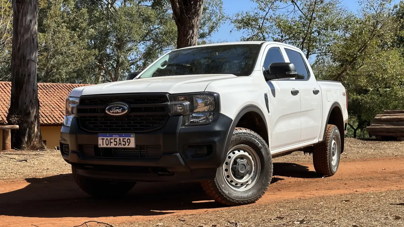 Caminhonete Ford Ranger XL branca parada de frente em estrada de terra