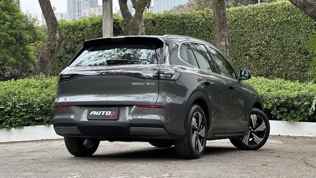 Geely EX5 Max cinza parado de traseira com árvores ao fundo