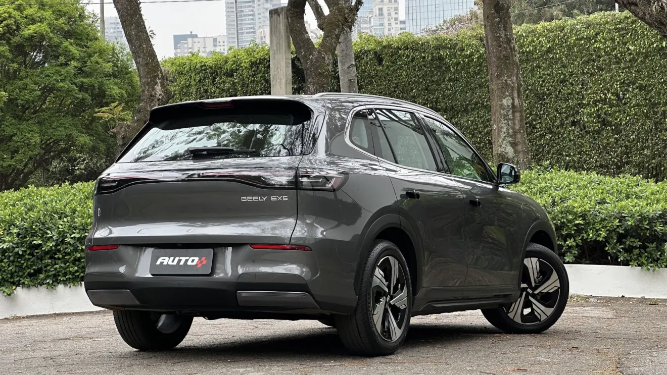 Geely EX5 Max cinza parado de traseira com árvores ao fundo