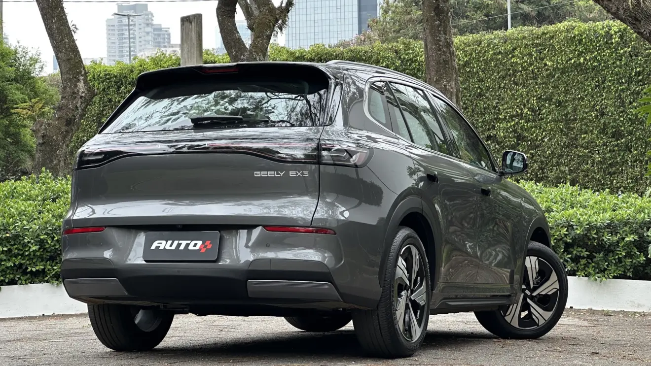 Geely EX5 Max cinza parado de traseira com árvores ao fundo