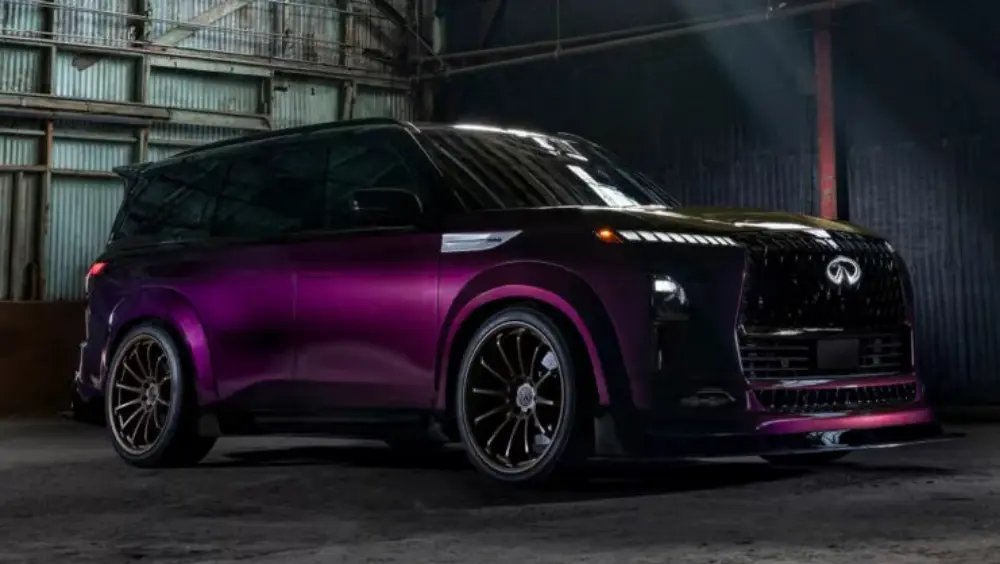 Infiniti QX80 R-Spec roxo visto de lado e com iluminação acesa