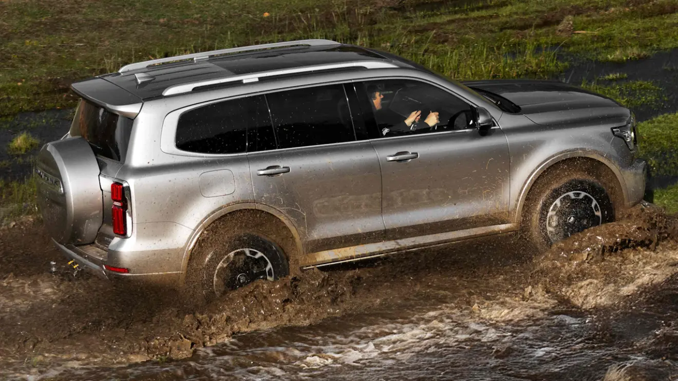 GWM Tank 500 prata visto de lado e andando na lama