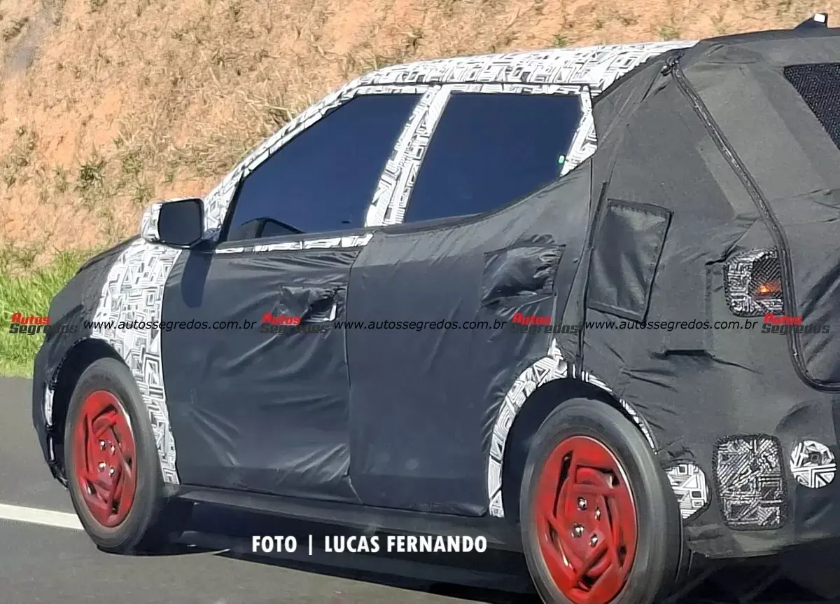 Protótipo do novo Hyundai HB20 camuflado de preto e branco e visto de lado