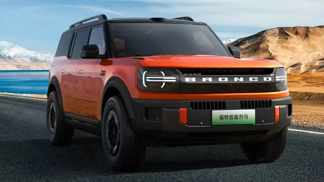 Ford Bronco elétrico laranja visto de frente e com iluminação acesa