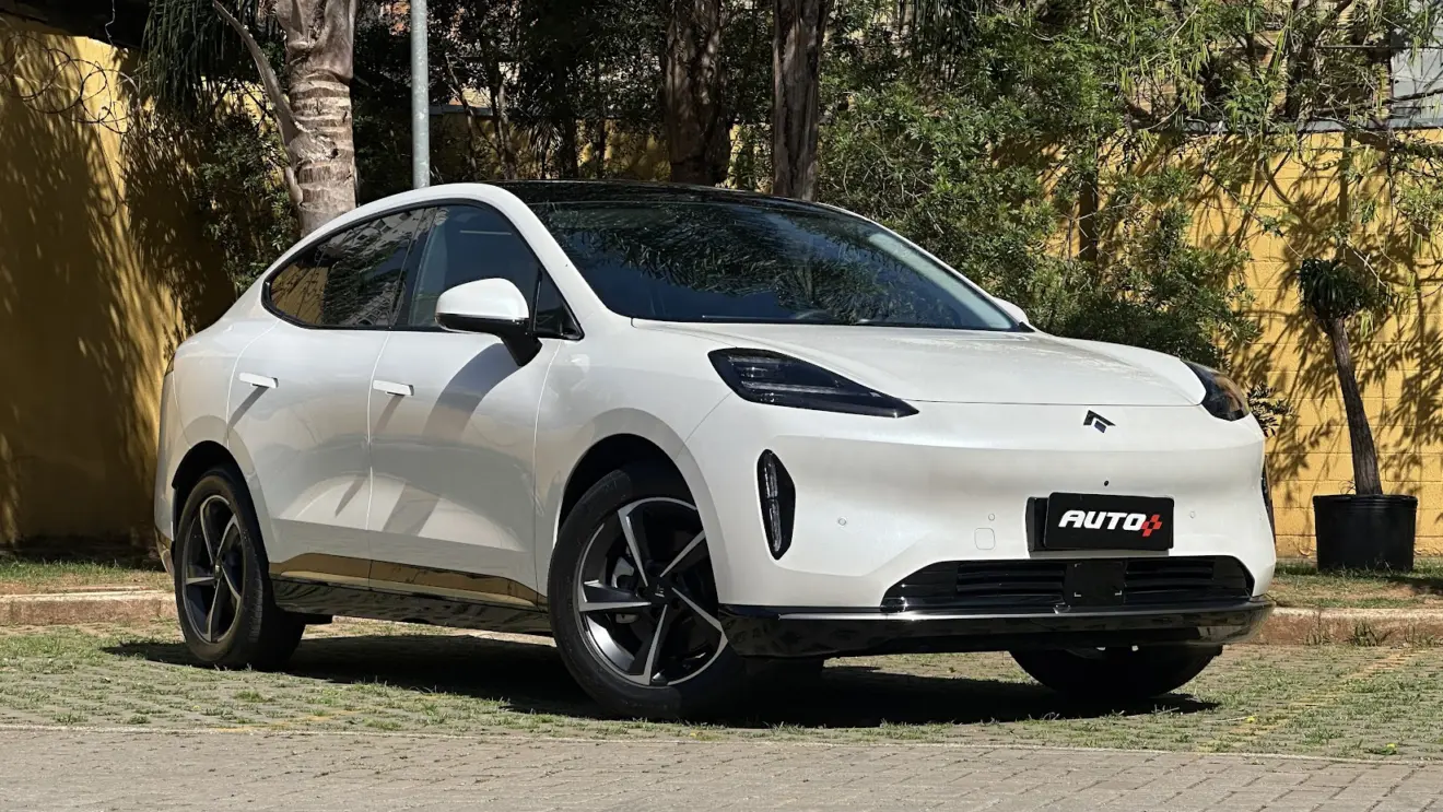 GAC Hyptec HT Elite branco parado de frente com muro amarelo e plantas ao fundo