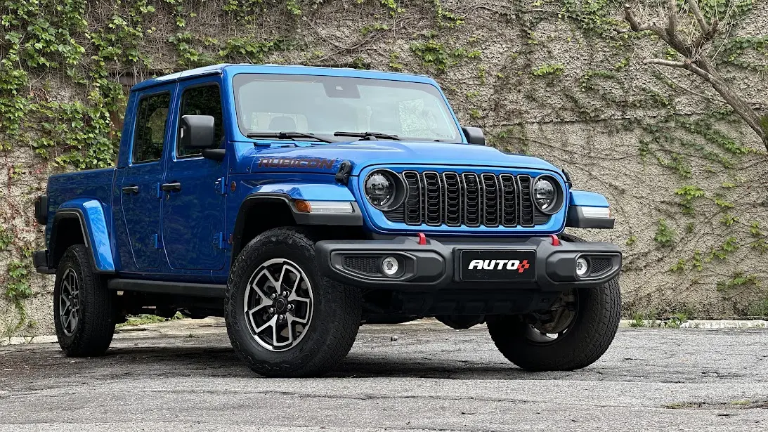 Jeep Gladiator Rubicon azul parado de frente com muro ao fundo