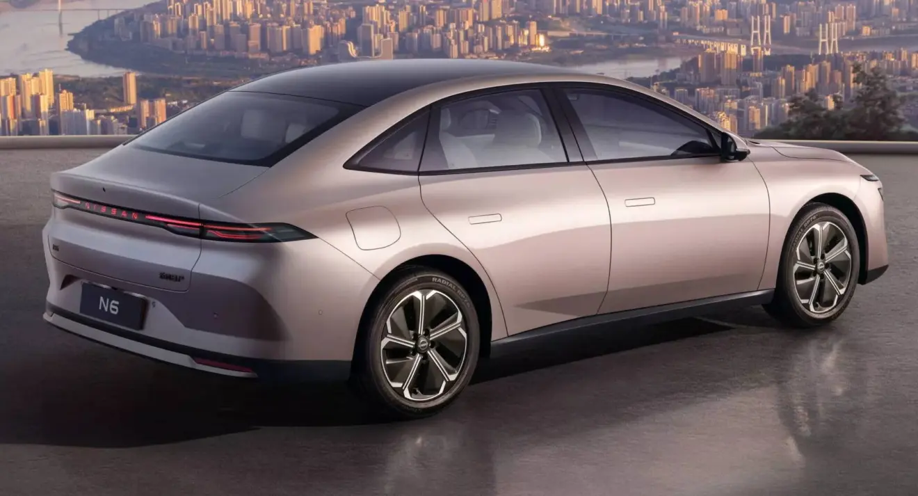 Nissan N6 dourado parado de traseira com cidade ao fundo