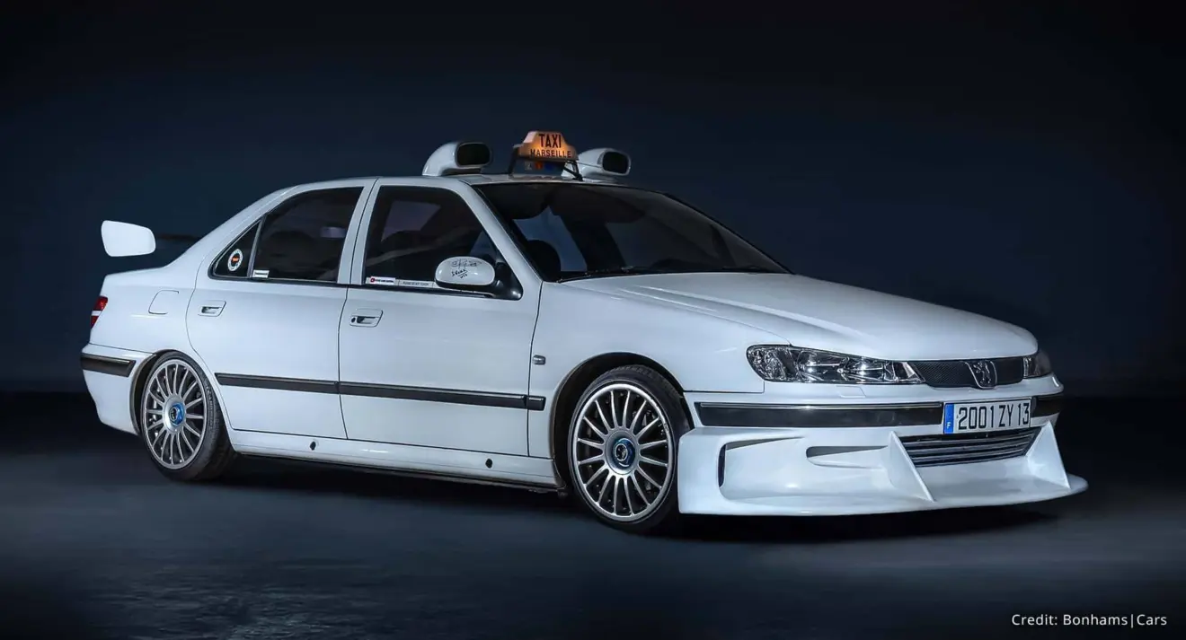 Peugeot 406 V6 branco parado de frente é o carro que participou do filme Taxi 2