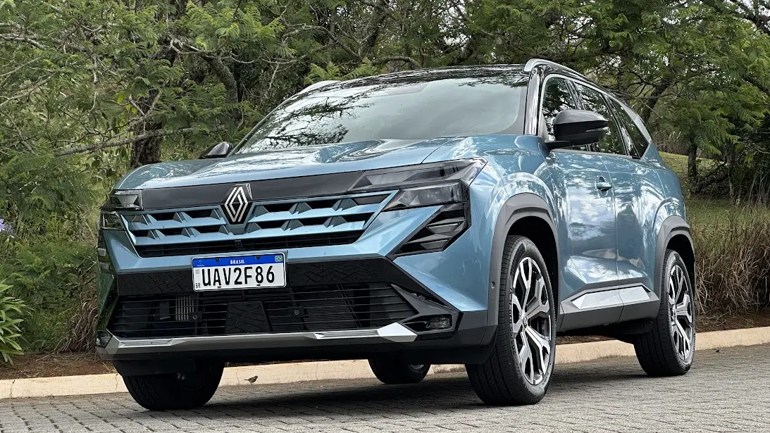 Renault Boreal Iconic azul parado de frente com árvores ao fundo