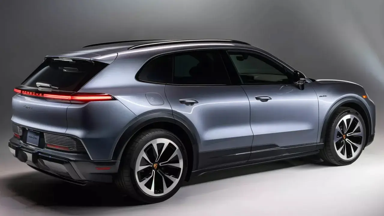 Porsche Cayenne elétrico cinza visto de trás e com lanternas acesas