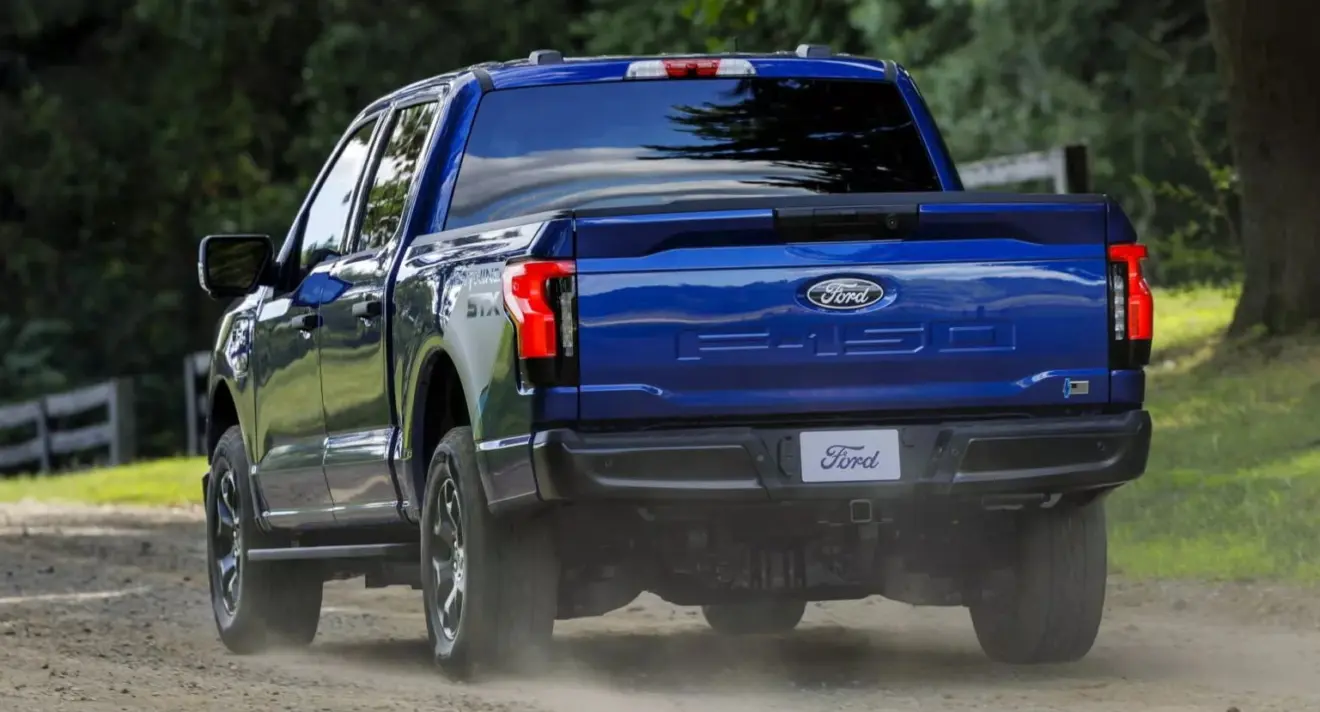 Caminhonete Ford F-150 Lightning azul em movimento de traseira no off-road