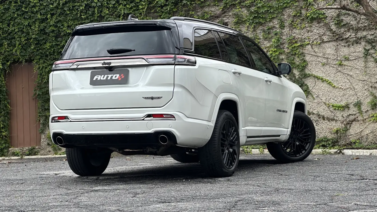 Jeep Commander Blackhawk branco parado de traseira com muro de cimento ao fundo