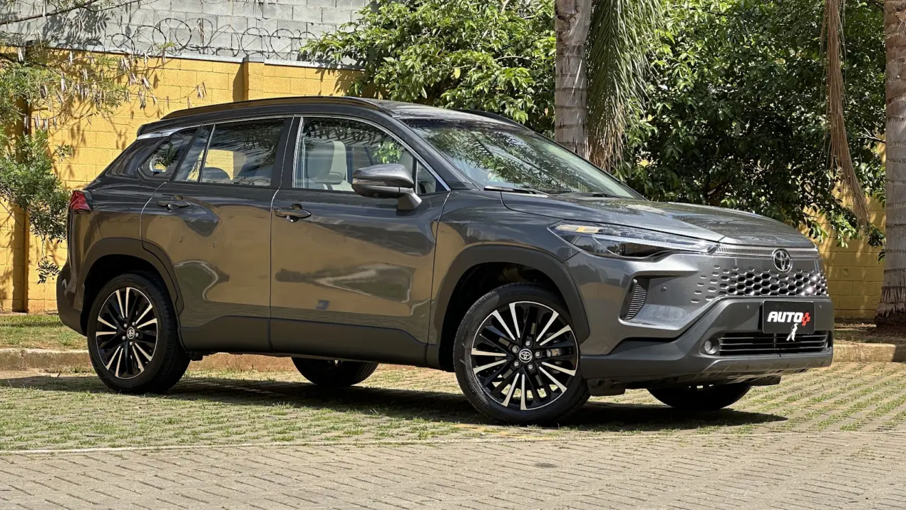 Utilitário esportivo Toyota Corolla Cross XRX cinza parado de frente com muro amarelo e árvores ao fundo