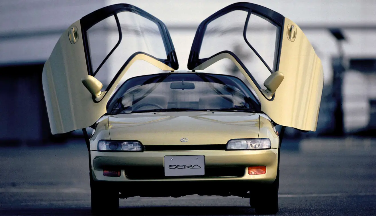 Toyota Sera dourado parado de frente foi um carro com portas diferentes