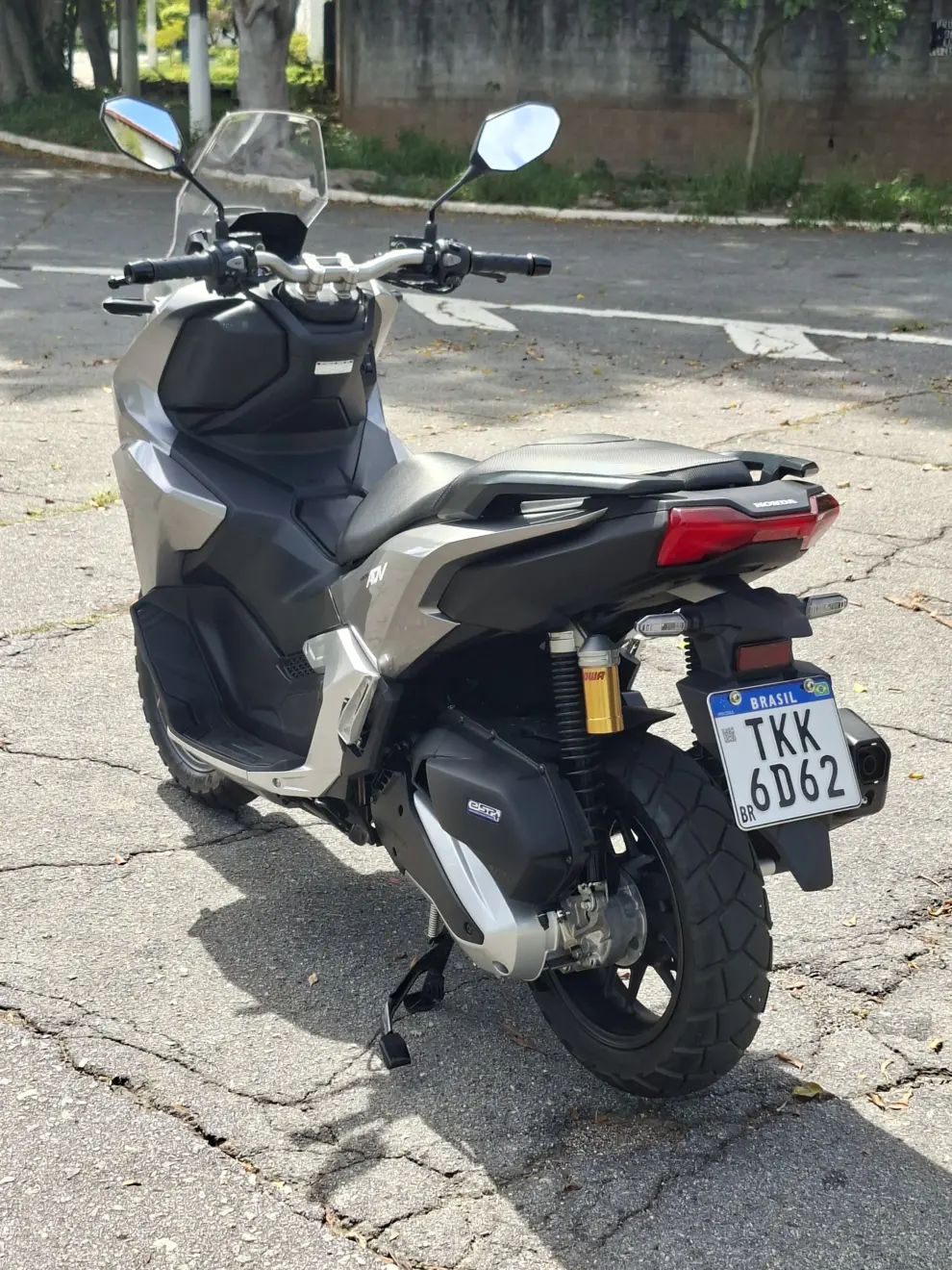 Honda ADV 160 cinza parada de traseira 