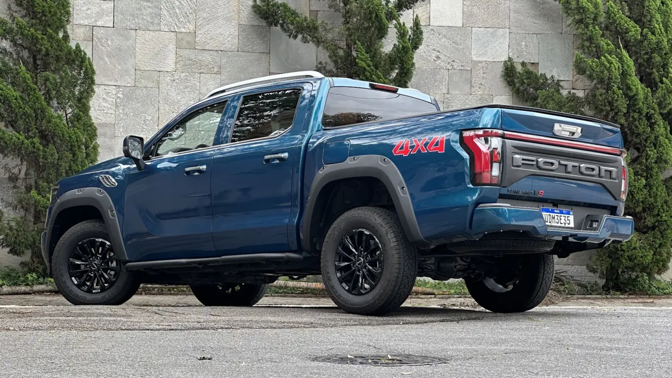 Foton Tunland V9 azul parada de traseira com árvores ao fundo