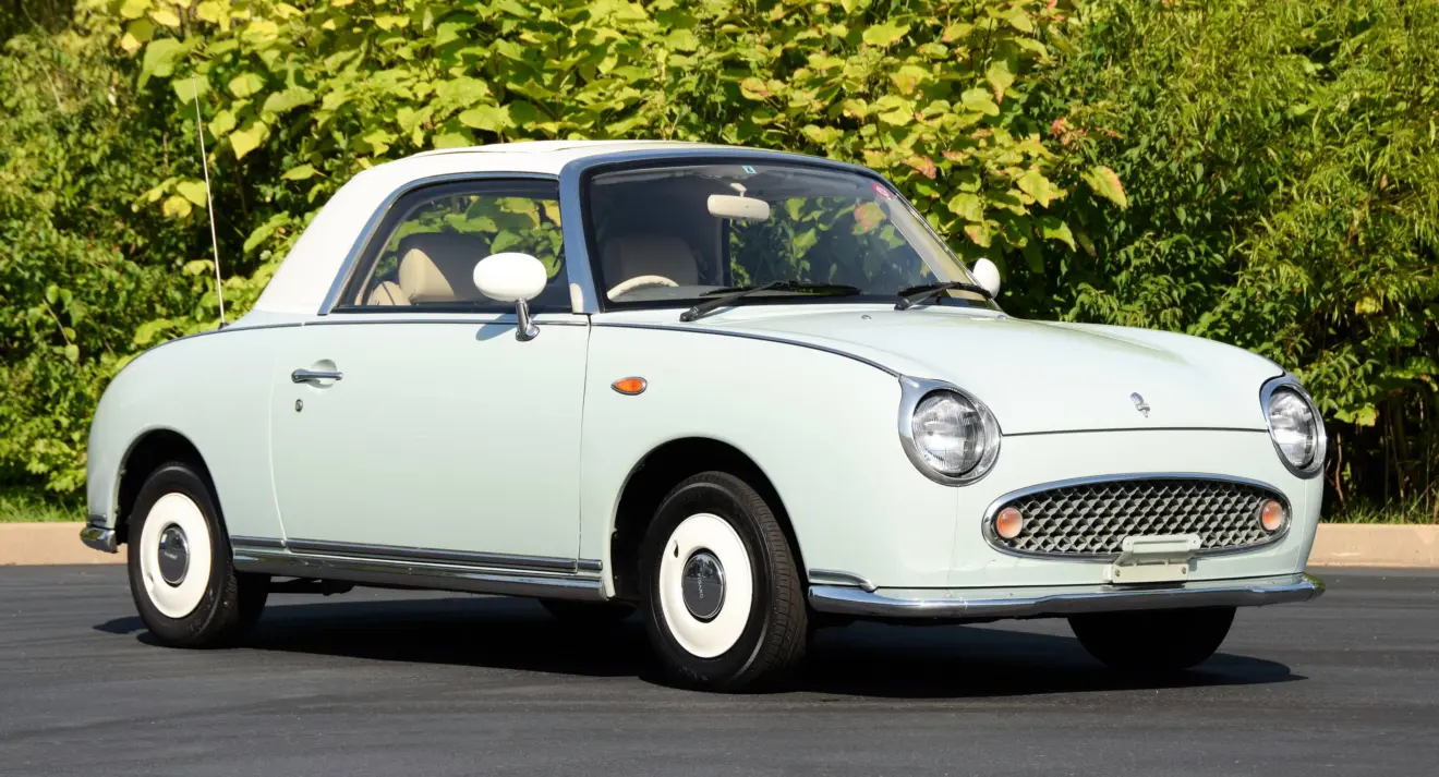 Nissan Figaro azul e branco parado de frente foi um carro que revolucionou o seu fabricante