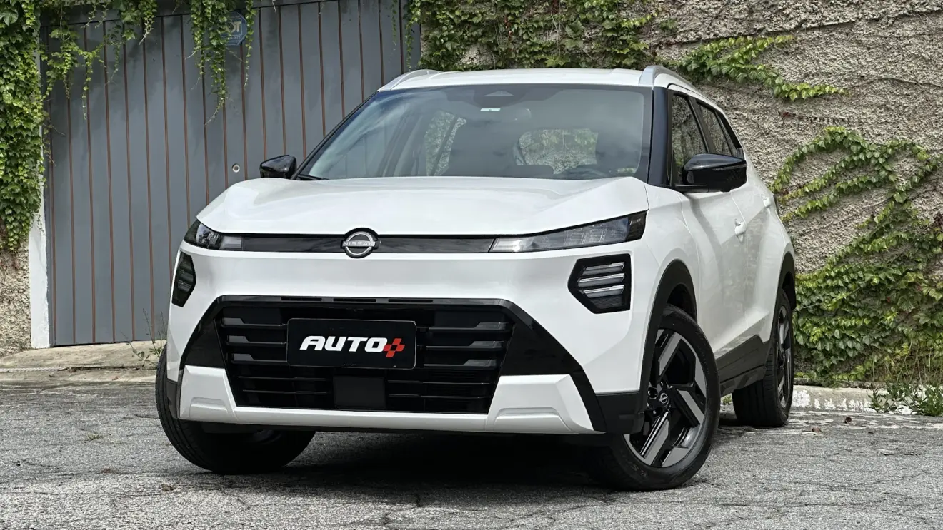 Nissan Kait Exclusive branco parado de frente com portão cinza e muro de cimento ao fundo