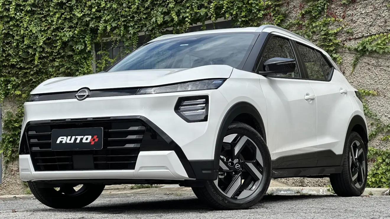 Nissan Kait Exclusive branco parado de frente com portão cinza e muro de cimento ao fundo